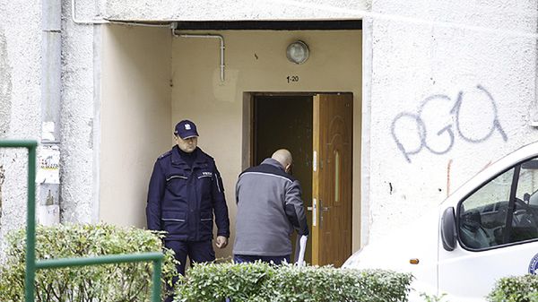 Policjant przed wejściem do bloku, w którym znaleziono ciało 2,5-letniej dziewczynki