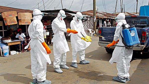Dezynfekcja pracowników wynoszących z domów ciała zmarłych na Ebolę w Liberii