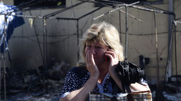 Kobieta płacze przed swoim zniszczonym sklepem w Doniecku