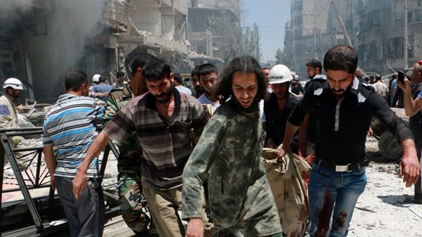 Ratownicy przenoszą ciała ofiar bombardowania w Aleppo