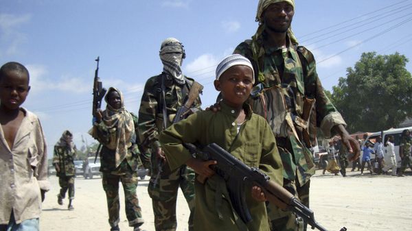 Somalijski chłopiec w otoczeniu członków Al-Szabab, Mogadiszu, 2010 r.