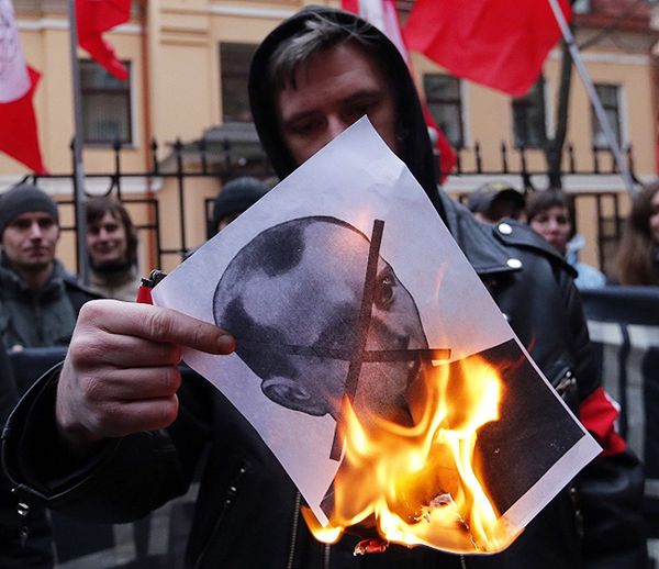Protest przed konsulatem Ukrainy w Petersburgu. Demonstrant pali zdjęcie Stepana Bandery