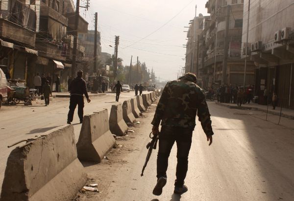 Syryjski rebeliant idzie ulicą Aleppo