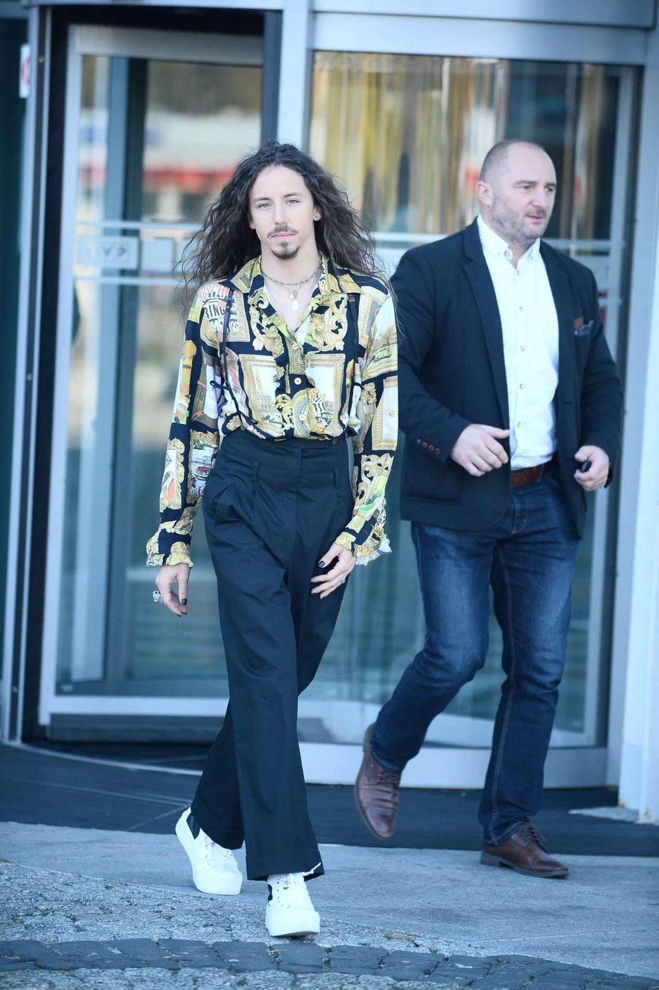 Michał Szpak w czarnych spodniach i koszuli we wzór