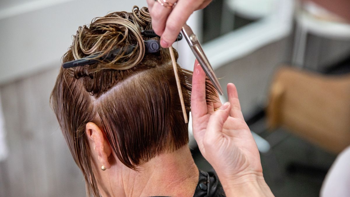 Fryzjer obcina włosy kobiecie