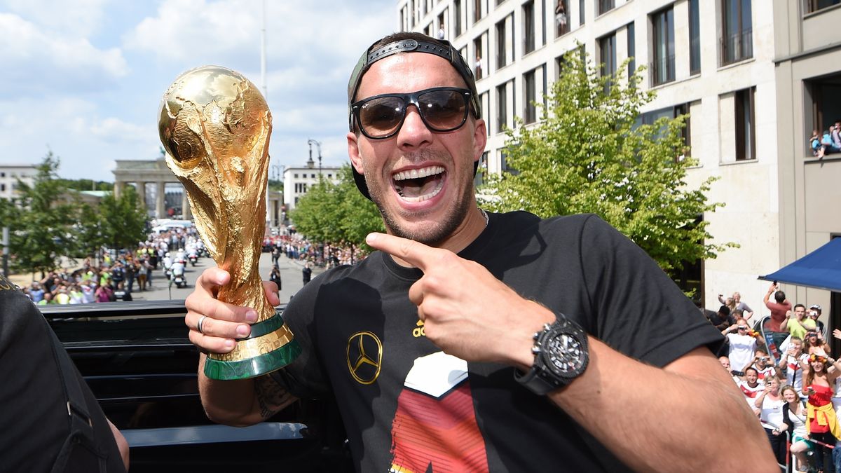 Lukas Podolski z trofeum za wygranie mundialu w 2014 roku