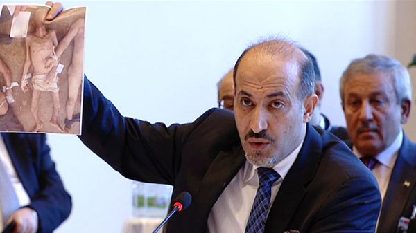 Ahmad Dżarba pokazuje zdjęcie torturowanych opozycjonistów