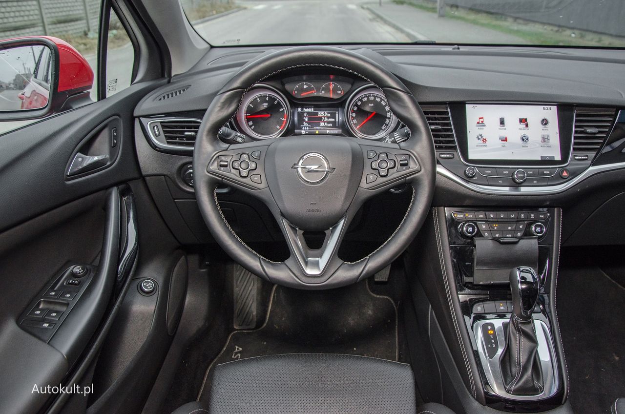 Opel Astra K – początkowo stosowano klasyczne wskaźniki, ale od 2019 r. pojawiły się cyfrowe. Uwagę zwraca ciekawy i wyglądający jak akcesoryjny uchwyt na smartfon