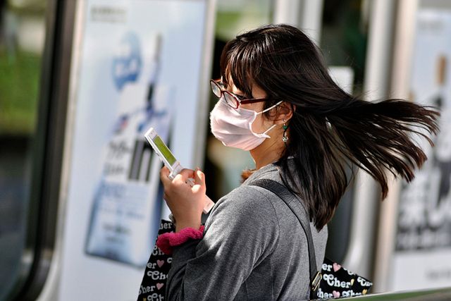 Kobieta w masce z telefonem na dworcu ;) (fot. flickr/by colidio/lic. CC)
