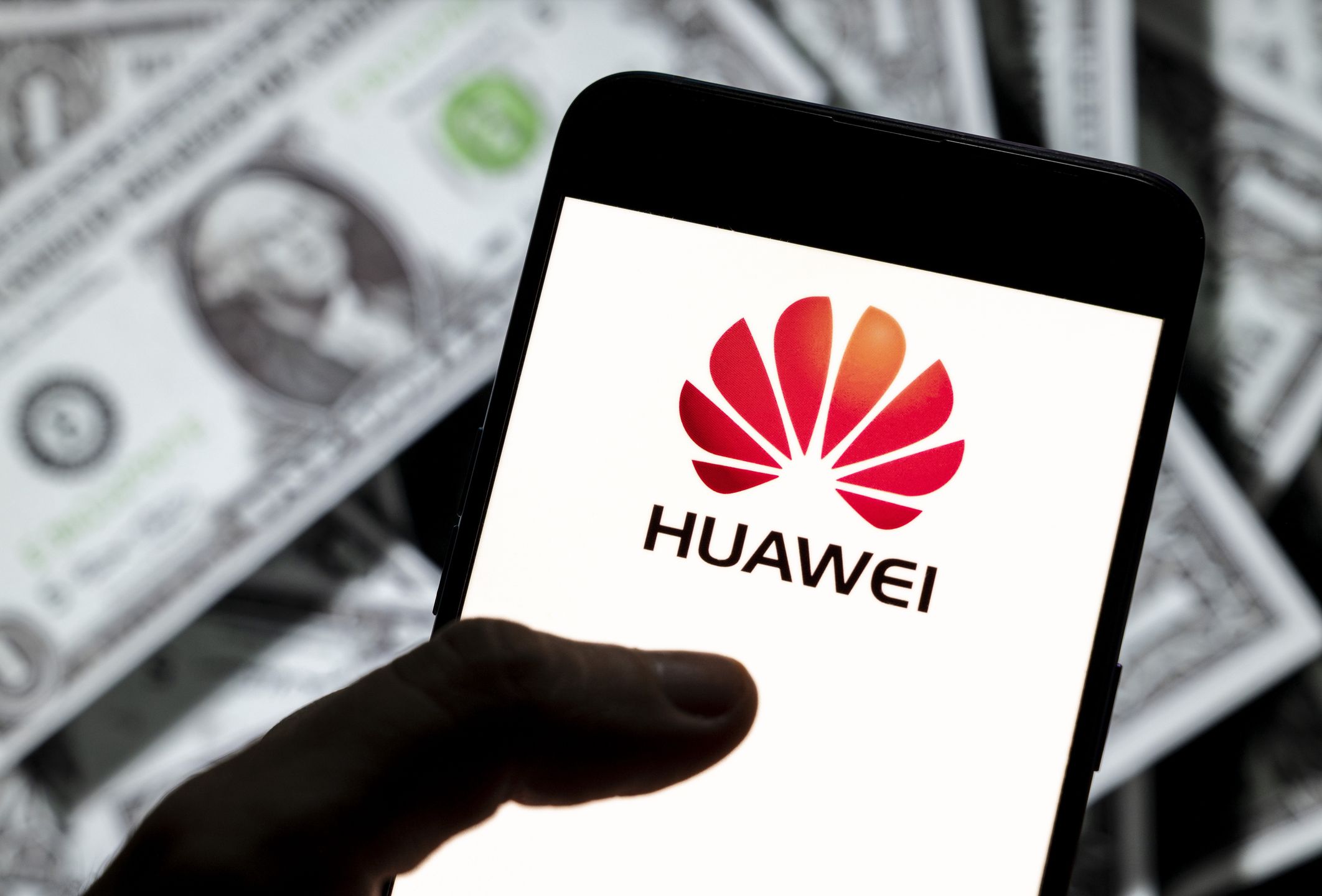 CHINA - 2021/04/13: In this photo illustration, the Chinese multinational telecommunications equipment and consumer electronics company Huawei logo seen on an Android mobile device screen with the currency of the United States dollar icon, $ icon symbol in the background. (Photo Illustration by Budrul Chukrut/SOPA Images/LightRocket via Getty Images)
