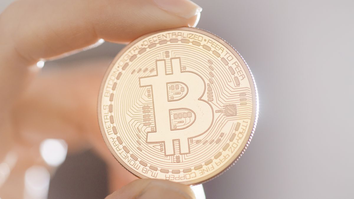 BERLIN, GERMANY - MARCH 10: Symbolic photo on the subject of Bitcoin - virtual currency. A bitcoin coin is held in one hand on March 10, 2022 in Berlin, Germany. (Photo by Thomas Trutschel/Photothek via Getty Images)