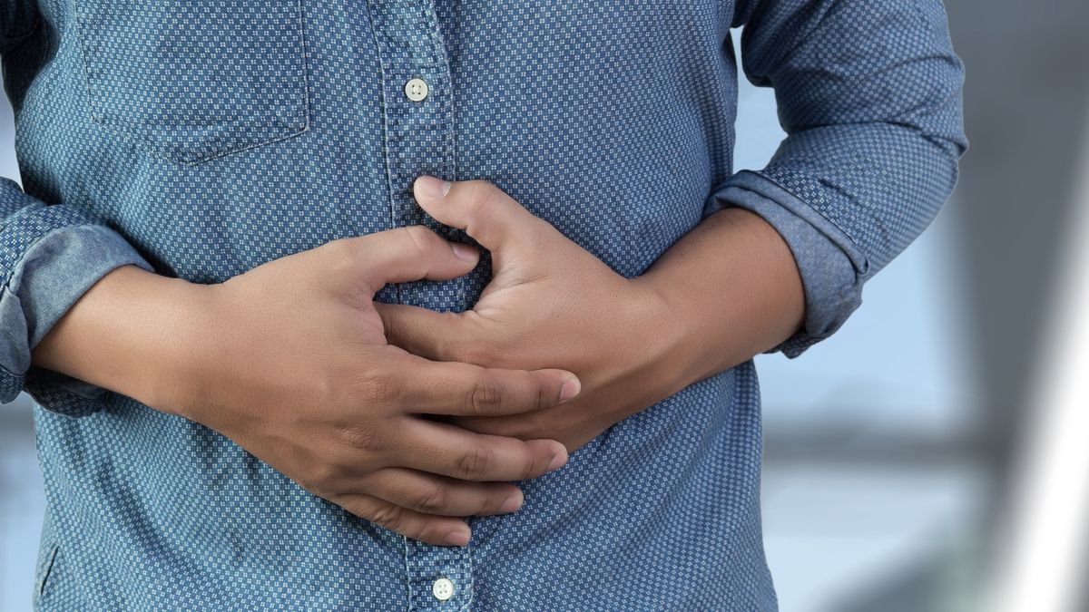 Midsection Of Man Touching Abdomen While Standing Against White BackgroundNipitphon Na Chiangmai / EyeEmhorizontal image, suffering