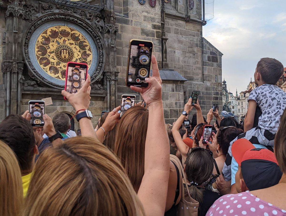 Przed pełną godziną turyści zbierają się pod zegarem astronomicznym 