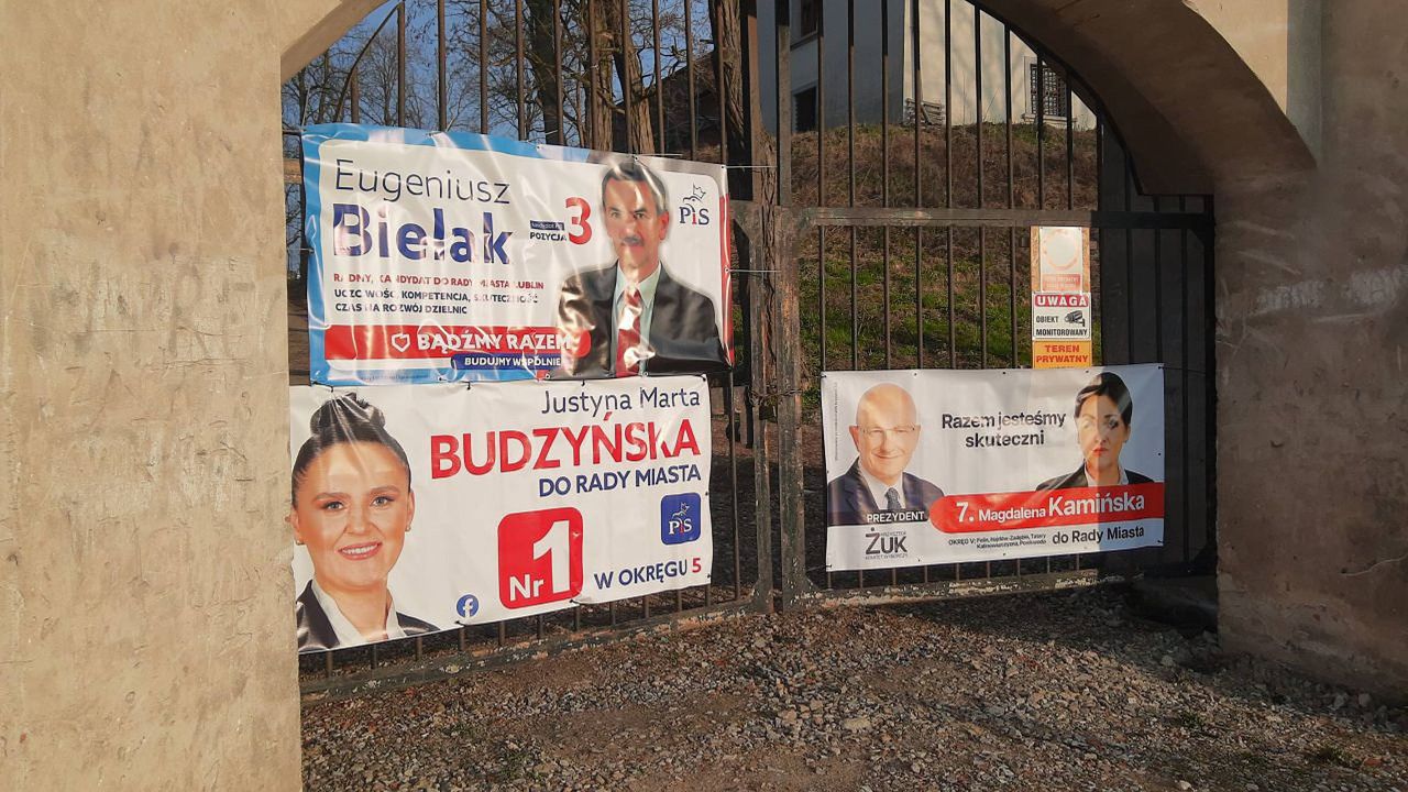 Banery wyborcze na zabytkowej bramie w Lublinie