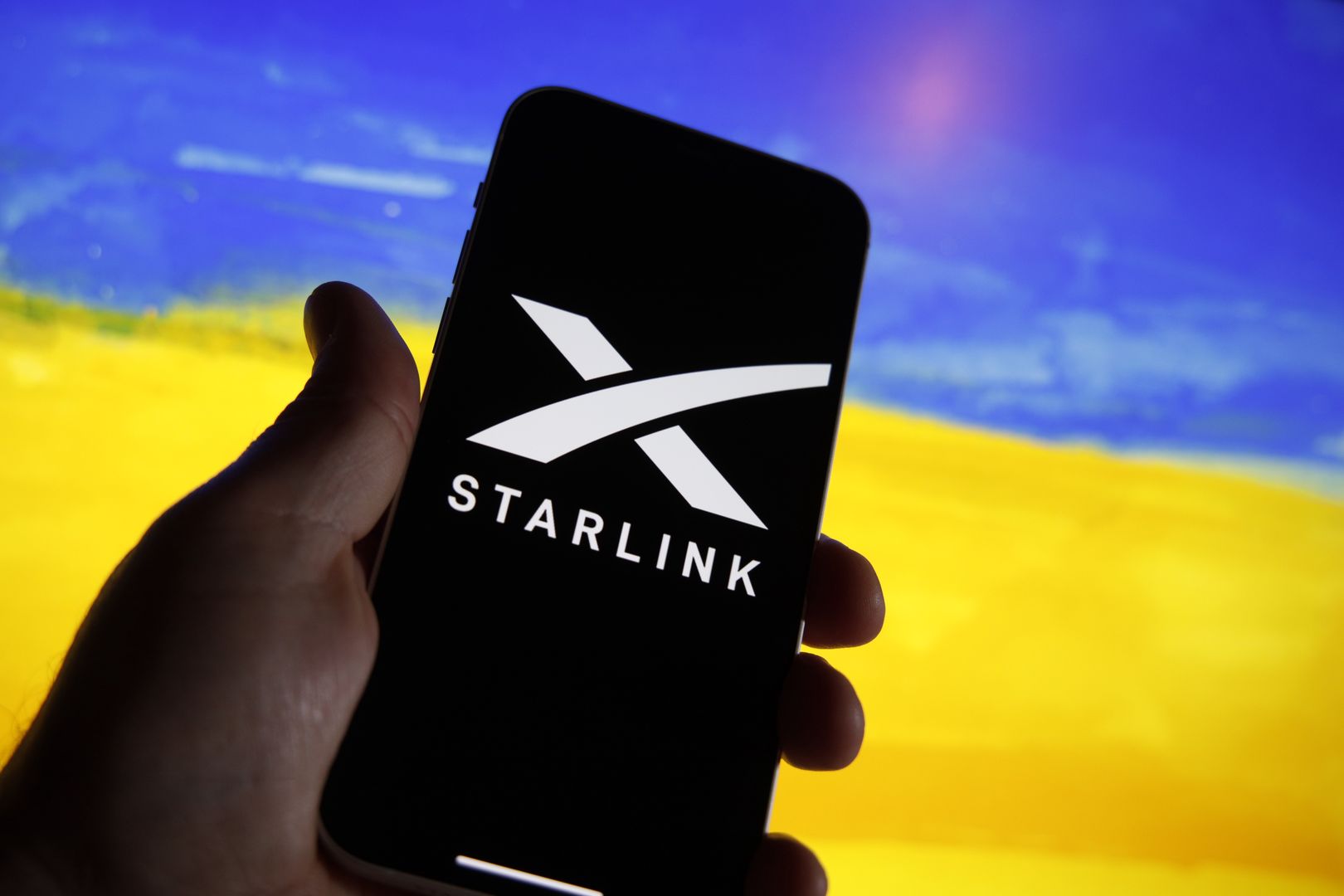 The Starlink logo is seen on a mobile device with a Ukrainian flag in the background in this illustration photo in Warsaw, Poland on 21 September, 2022. Starlink owner and founder Elon Musk Starlink owner Elon Musk has decided to have the satellite company resume internet services in Ukraine after complaints of Starlink owner Elon Musk has decided to have the satellite company resume internet services in Ukraine after complaints of substantial costs. The satellite service, provided for free, is essential to the armed forces of Ukraine batteling Russian forces. (Photo by STR/NurPhoto via Getty Images)