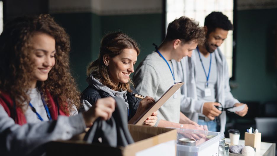 Group of volunteers working in community charity donation center.A group of volunteers working in community charity donation center.group, people, volunteers, community, center, indoors, donation, work, charity, caucasian, african-american, multi-ethnic, man, woman, outreach, humanitarian aid, help, collection, box, team, organization, sorting, clothes, canned, food, support, care, service, altruism