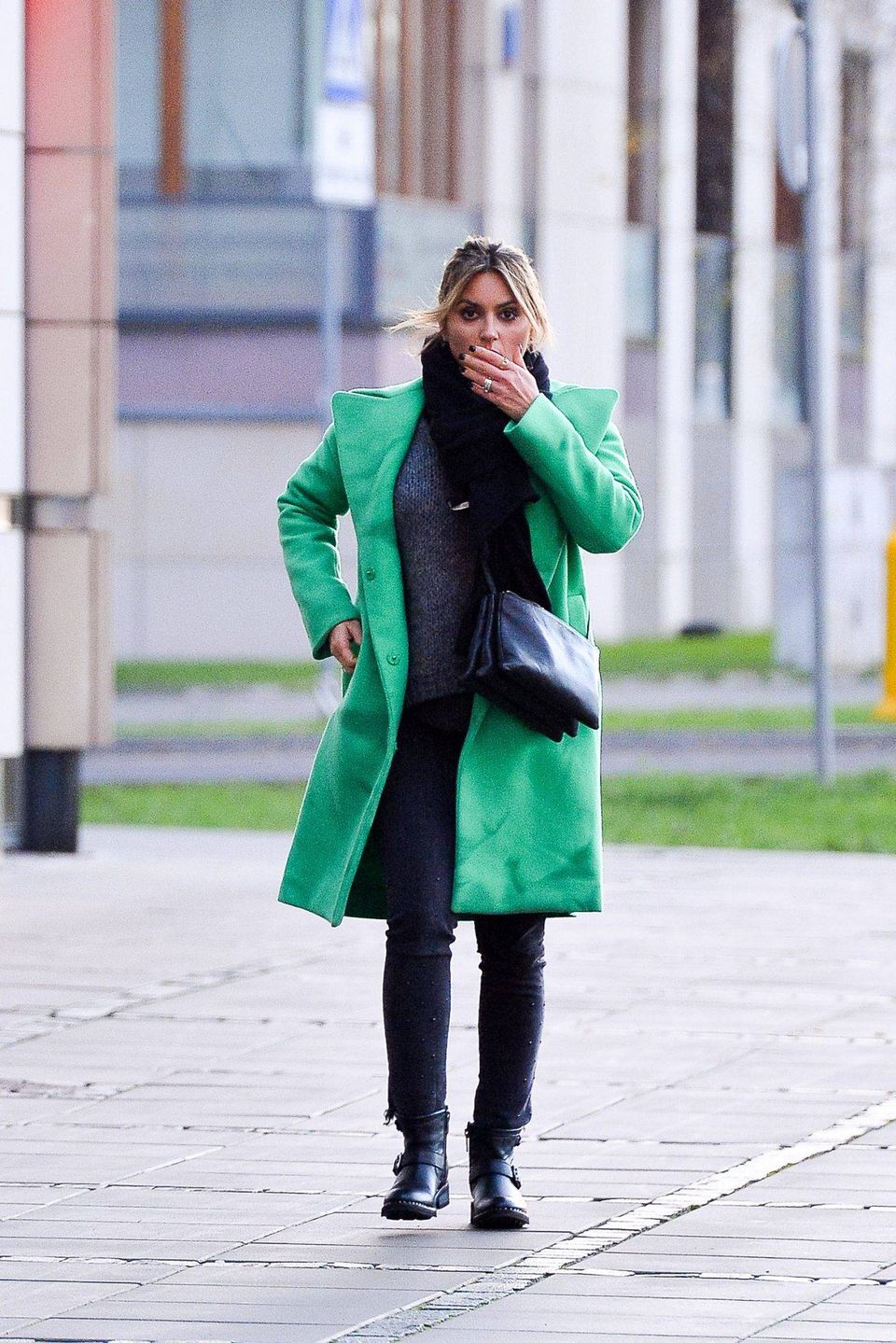 Karolina Szostak w zielonym płaszczyku w banku