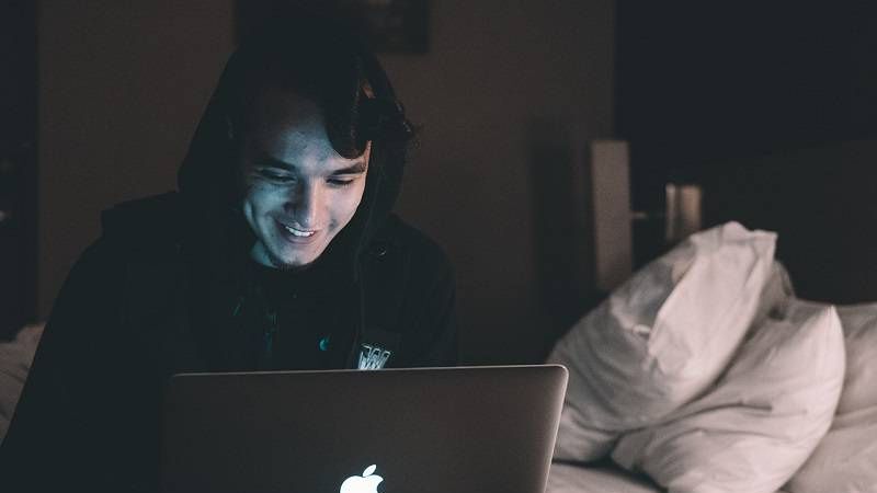 chłopak przed laptopem apple
