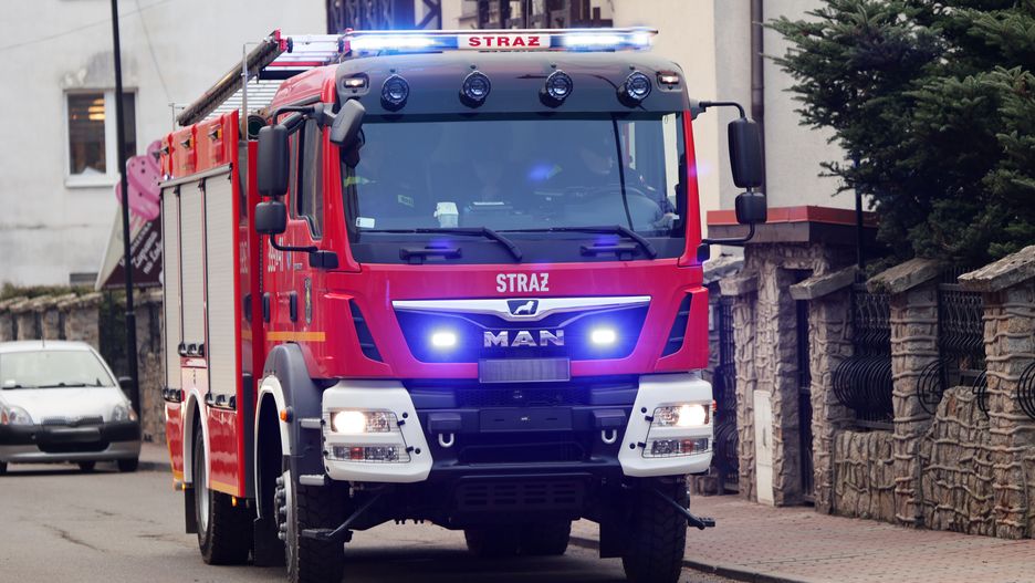 Funkcjonariusze straży pożarnej w swoim samochodzie jadą do akcj