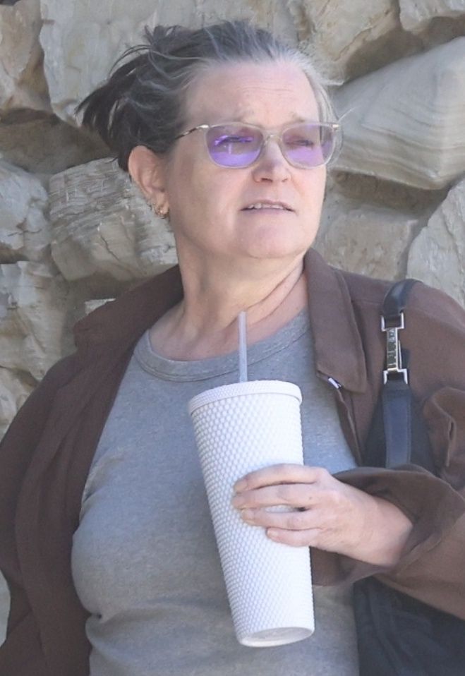 Odmieniona Bridget Fonda na spacerze z psem
