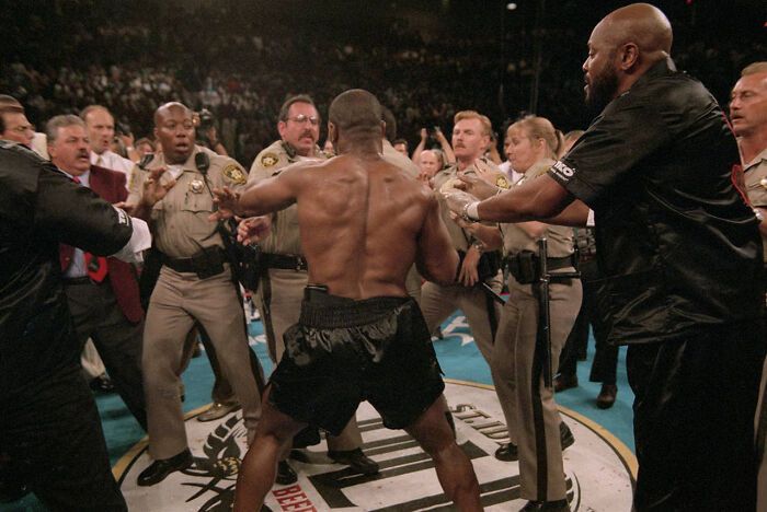 Policja próbuje zatrzymać Mike'a Tysona po tym, jak odgryzł kawałek ucha Holyfieldowi. 1996.