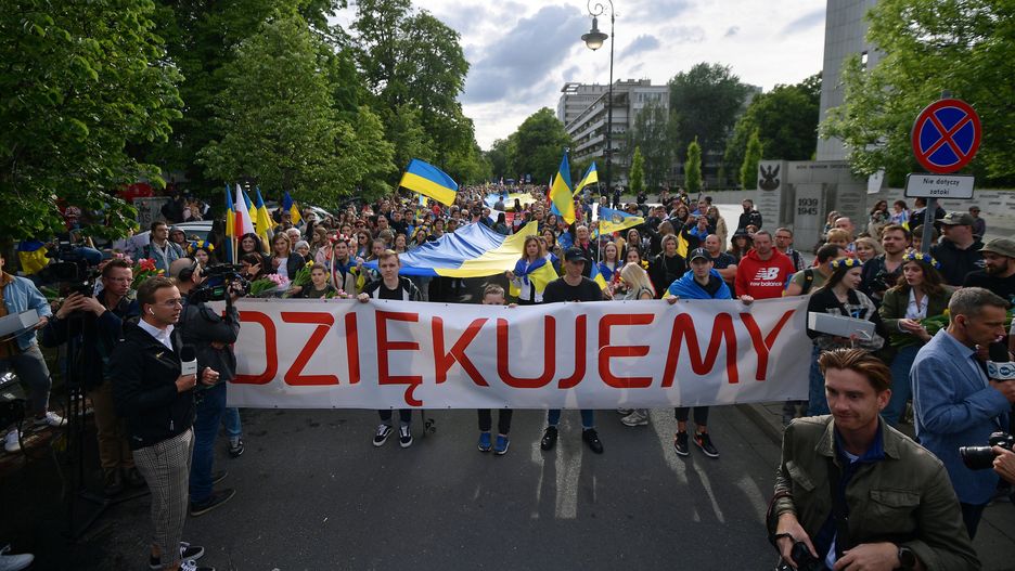 Warszawa, 29.05.2022. Obywatele Ukrainy podczas Marszu Wdzięczności w Warszawie, 29 bm. Marsz Wdzięczności organizowany został przez Ukraińców, którzy przybyli do Polski w związku z agresją Rosji na ich kraj. Ukraińcy przyszli na wydarzenie z kwiatami, które rozdają Polakom, dziękując za wsparcie w tak trudnym dla nich czasie. (sko) PAP/Marcin Obara