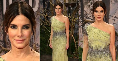 Elegancka Sandra Bullock pozuje na tle suchych gałęzi