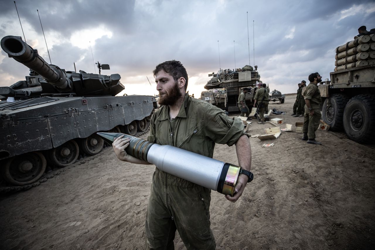Izraelski żołnierz ładuje amunicję do czołgu pod granicą ze Strefą Gazy
