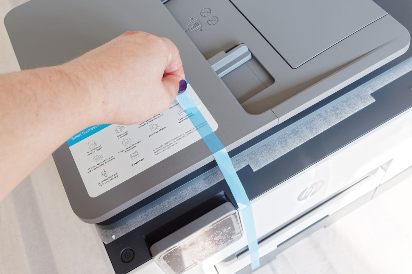 Muszę usunąć tę taśmę i  podkładkę, zabezpieczającą szybę skanera 