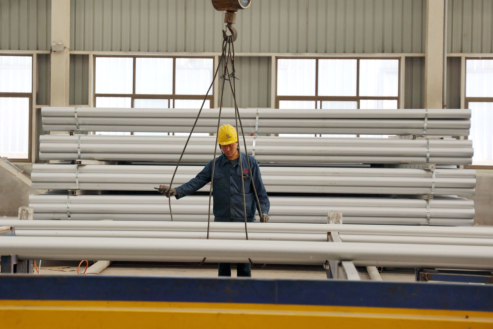 BINZHOU, CHINA - MAY 13: A worker prepares to hoist aluminum alloy rods at the workshop of an aluminum product manufacturing enterprise on May 13, 2025 in Binzhou, Shandong Province of China. (Photo by Chu Baorui/VCG via Getty Images)
