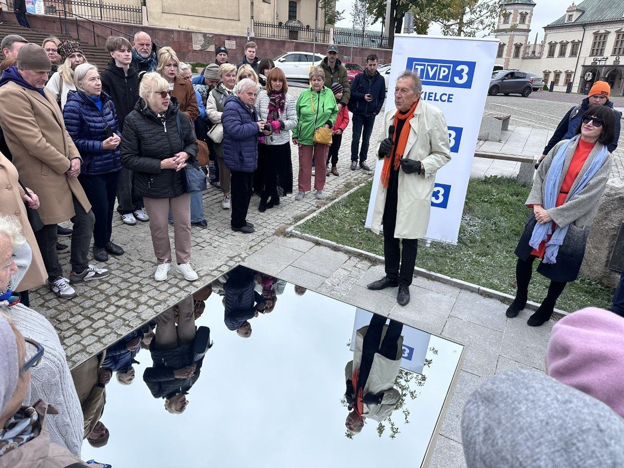Marek Cecuła - w pomarańczowym szaliku - podczas odsłonięcia instalacji w Kielcach.  