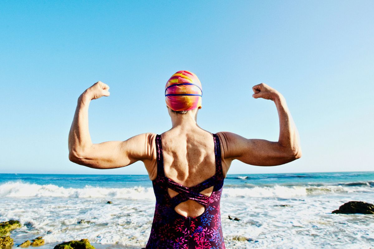 The swimmer flexes her muscles.