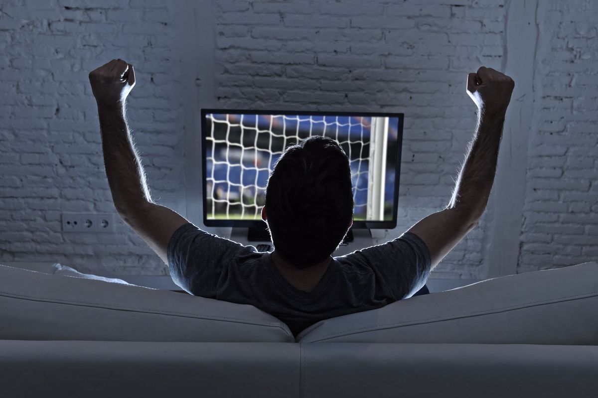 Back,View,Of,Young,Man,Home,Alone,Watching,Soccer,Or
