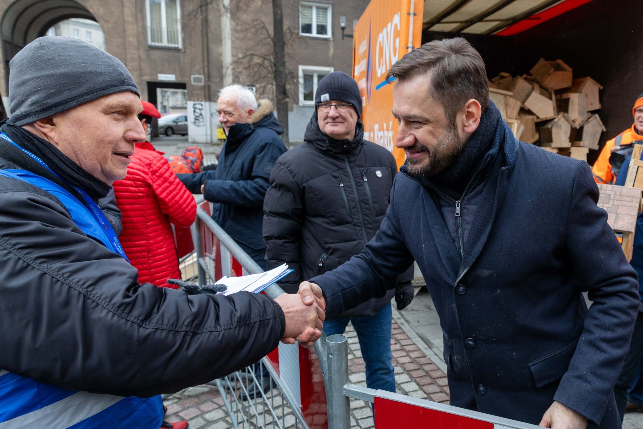Prezydent Krakowa ściska dłoń zwolennikowi referendum