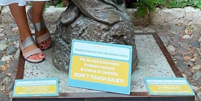Tabliczka o zakazie dotykania posągu Julii w Weronie