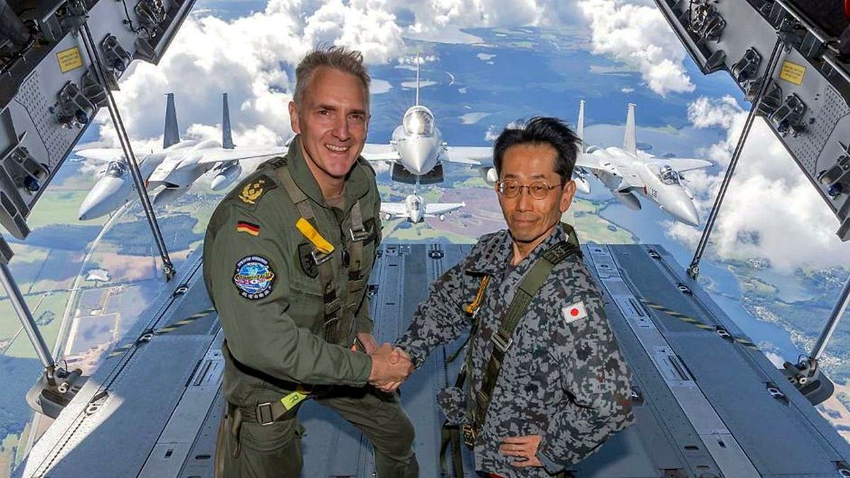 Dowódcy sił powietrznych Niemiec i Japonii na tle swoich maszyn.