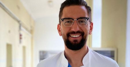 Dr Wojciech Falęcki pozuje z noworodkiem. "Cieszę się, że mimo trudnych czasów, miałeś lekkie lądowanie"