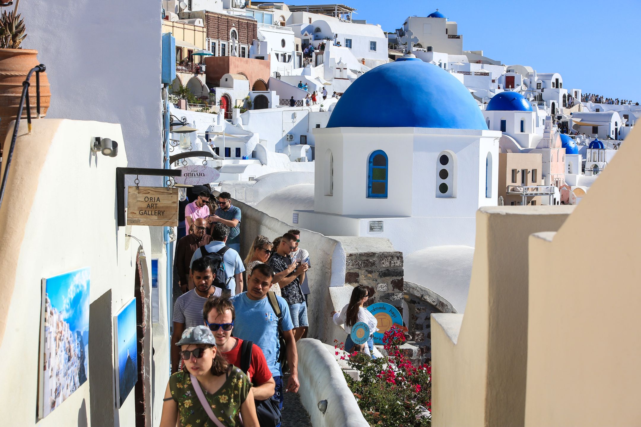 Turyści w sezonie wypełniają każdą uliczkę w Oia na Santorini