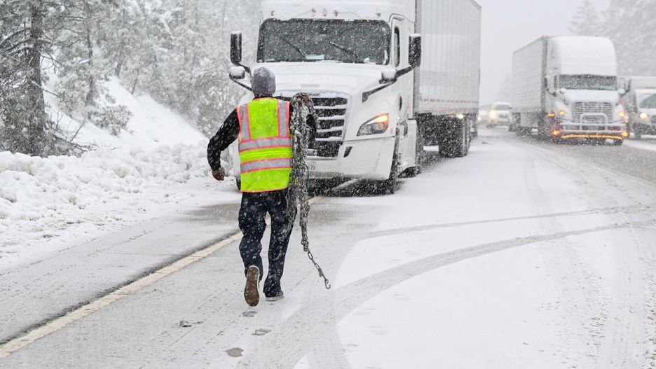 CALIFORNIA, USA - DECEMBER 13: A truck driver installs chains on his truck as a massive traffic on eastbound of Highway 80 during heavy snow in town of Camptonville near Truckee, California, United States on December 13, 2024. (Photo by Tayfun Coskun/Anadolu via Getty Images)