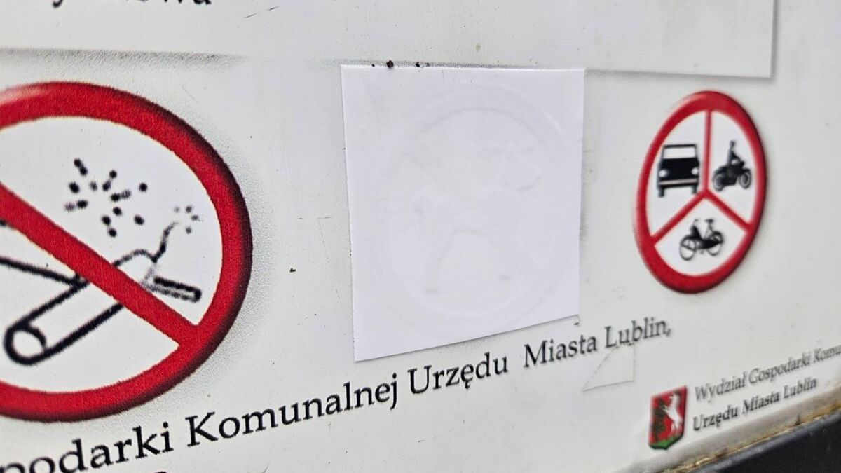 Zaklejony znak zakazu wyprowadzania psów na tablicy informacyjnej w Ogrodzie Saskim