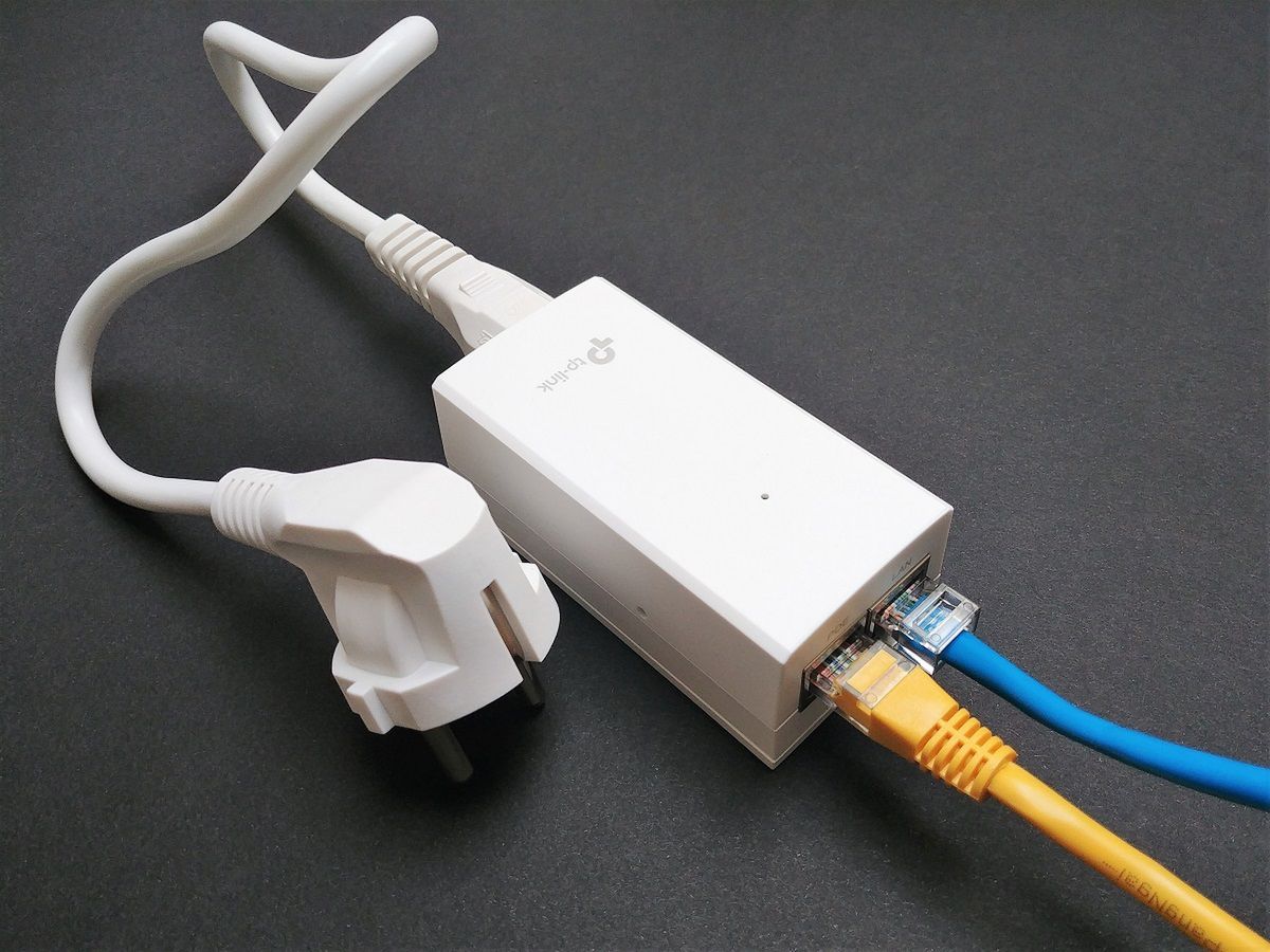 Zasilacz PoE jest w zestawie z punktem dostępowym Omada. Na powyższym zdjęciu niebieski przewód to połączenie LAN z dowolnym switchem, zaś żółta skrętka przekazuje już zarówno dane, jak i zasilanie.