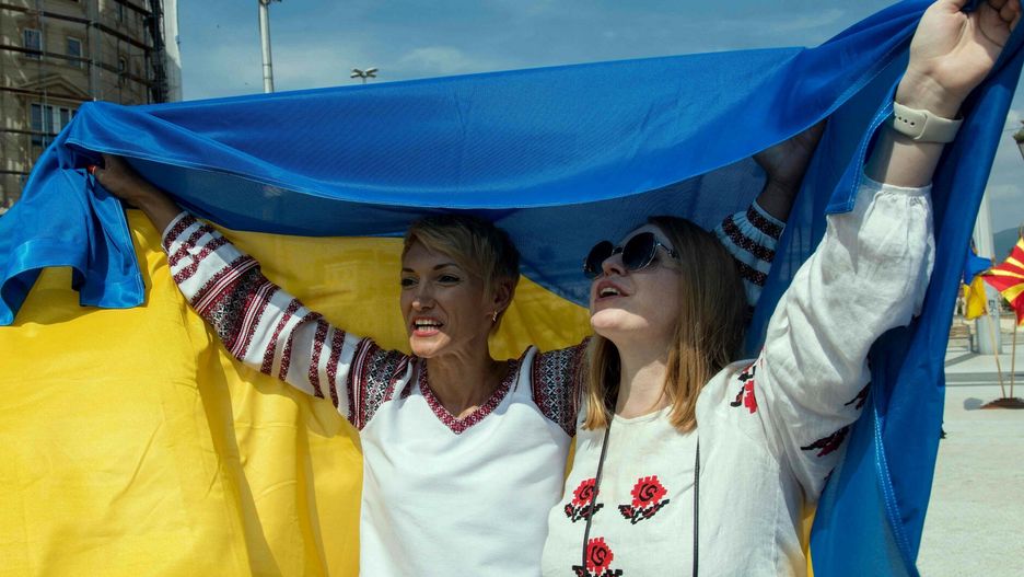 TemporaryProtesters hold Ukrainian flags and sing the Ukrainian national anthem on war-torn Ukraine's Independence Day, on the main square in Skopje, on August 24, 2022. - Six months to the day after the invasion of Ukraine by Russia, Ukrainian President Volodymyr Zelensky assured on August 24, 2022, that his country would fight "until the end" to regain all its territory, in a speech on the anniversary of Ukrainian independence from the USSR. (Photo by Robert ATANASOVSKI / AFP)ROBERT ATANASOVSKI