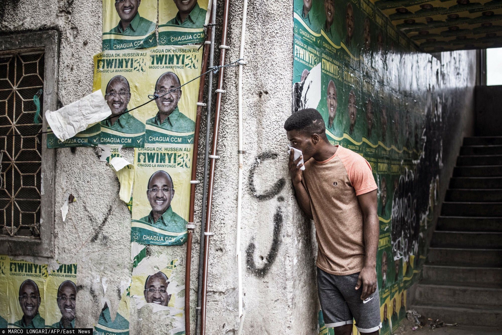 arch42TOPSHOT - A man covers his face to fight the effect of teargas while Zanzibar riot police carries out an operation after the opposition called for protests in Stone Town, on October 29, 2020 as tensions rise while the results of the general election are being announced. - Tanzania's main opposition presidential candidate on October 29, 2020 declared he would not recognise the election result as key seats fell to the ruling party in a vote he described as marred by irregularities. Counting was taking place across Tanzania and its semi-autonomous archipelago Zanzibar -- which also elects its own president and lawmakers -- where early results showed the opposition losing seats in some traditional strongholds. (Photo by MARCO LONGARI / AFP)MARCO LONGARI