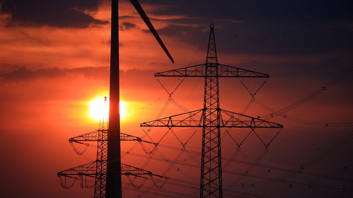Electricity towers, power lines and a wind turbine near Barnstorf, Lower Saxony, Germany, on Tuesday, Aug. 23, 2022. German power surged to above 700 euros ($696) a megawatt-hour for the first time as panic over Russian supplies gripped markets and politicians warned citizens to brace for a tough winter ahead. Photographer: Krisztian Bocsi/Bloomberg via Getty Images