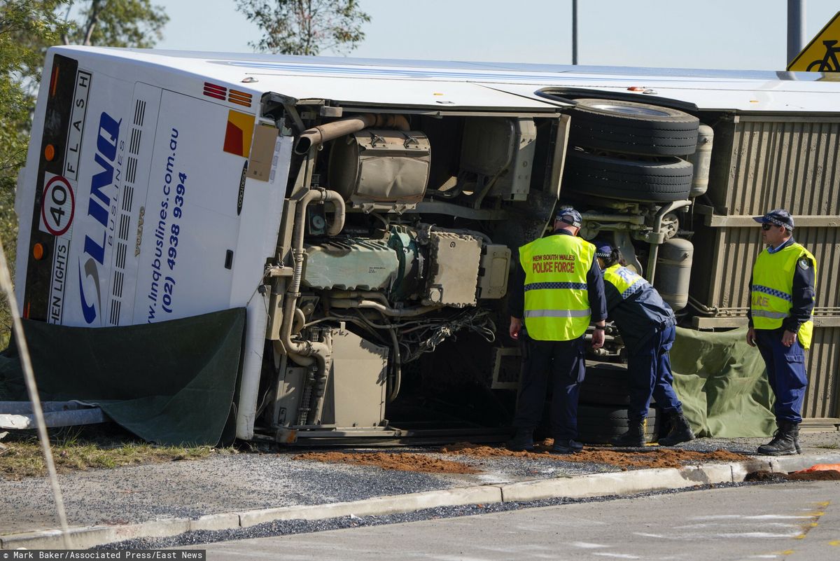 Policja sprawdza pod autobusem, który przewrócił się na bok w pobliżu Grety w Hunter Valley, na północ od Sydney, Australia, poniedziałek, 12 czerwca 2023 r.