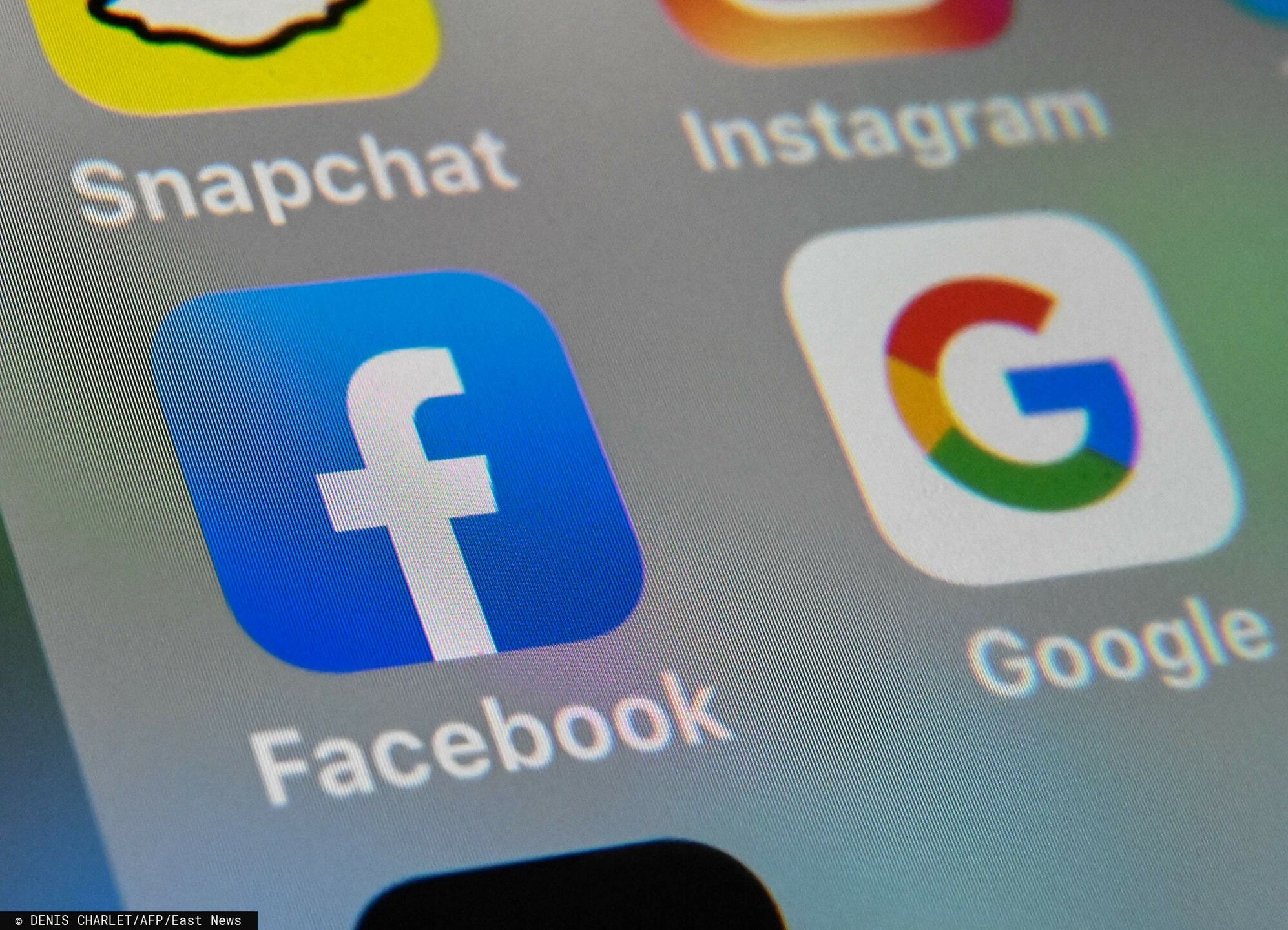 Temporary(FILES) This file photo taken on October 1, 2019, shows the logos of mobile apps Facebook and Google displayed on a tablet in Lille, France. - French regulators have hit Google and Facebook with 210 million euros ($237 million) in fines over their use of "cookies", the data used to track users online, authorities said on January 6, 2022. (Photo by DENIS CHARLET / AFP)DENIS CHARLET
