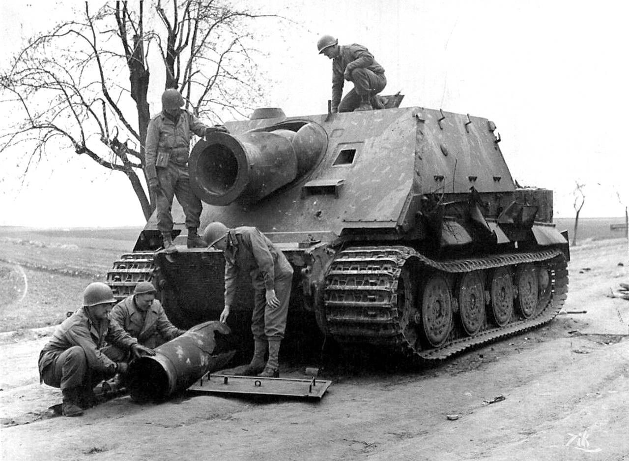 Sturmtiger oglądany przez amerykańskich żołnierzy. Przed pojazdem skorupa pocisku