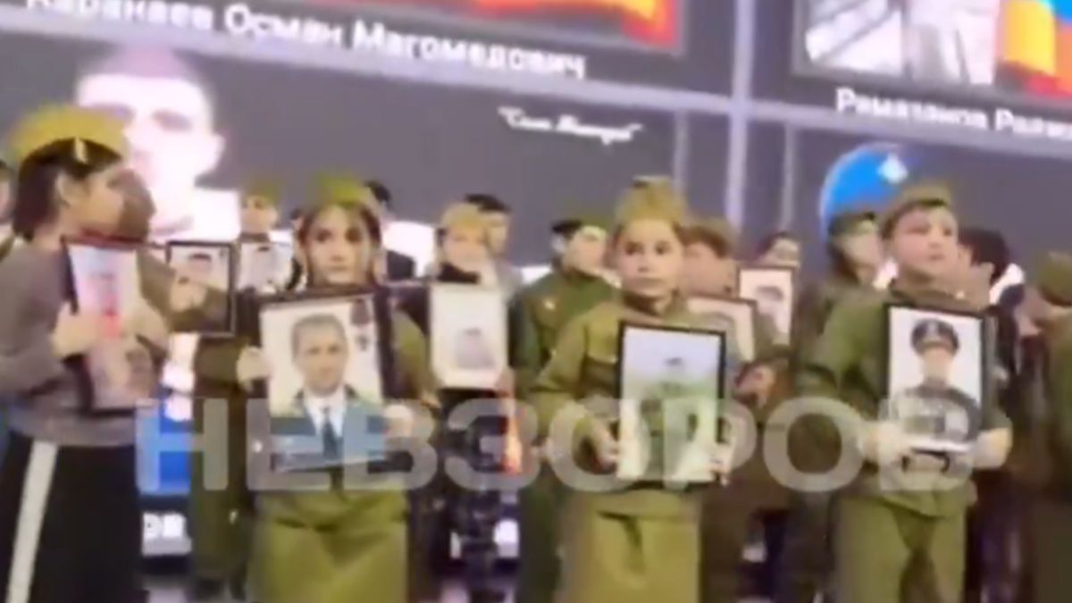 Rosyjskie dzieci z portretami wojskowych.