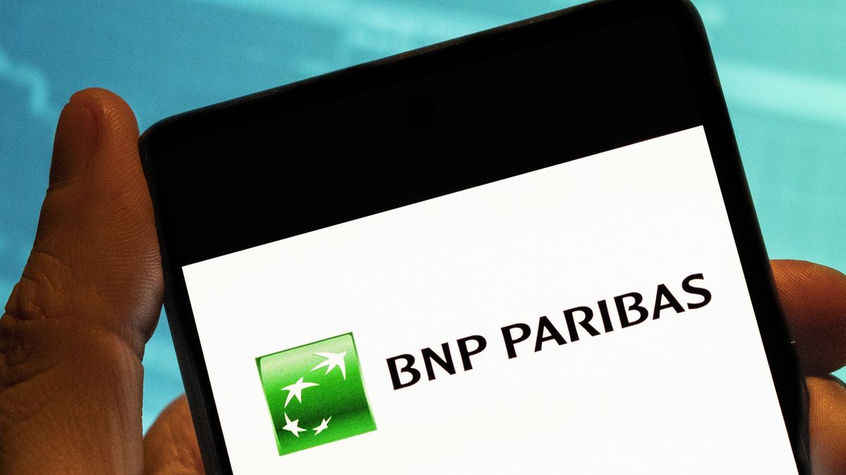 CHINA - 2023/02/19: In this photo illustration, the French international banking group BNP Paribas logo seen displayed on a smartphone with an economic stock exchange index graph in the background. (Photo Illustration by Budrul Chukrut/SOPA Images/LightRocket via Getty Images)