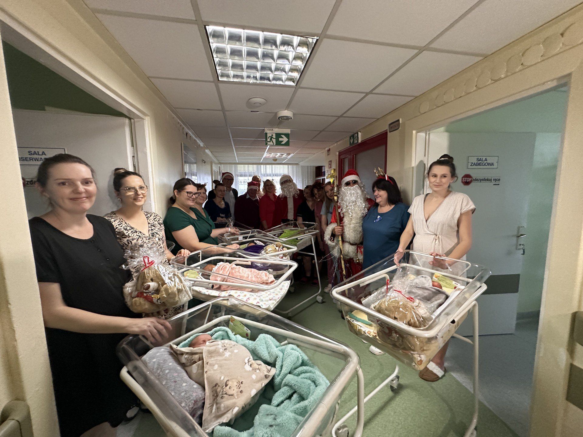 Wspólne zdjęcie z Mikołajami i gośćmi na oddziale noworodków. 